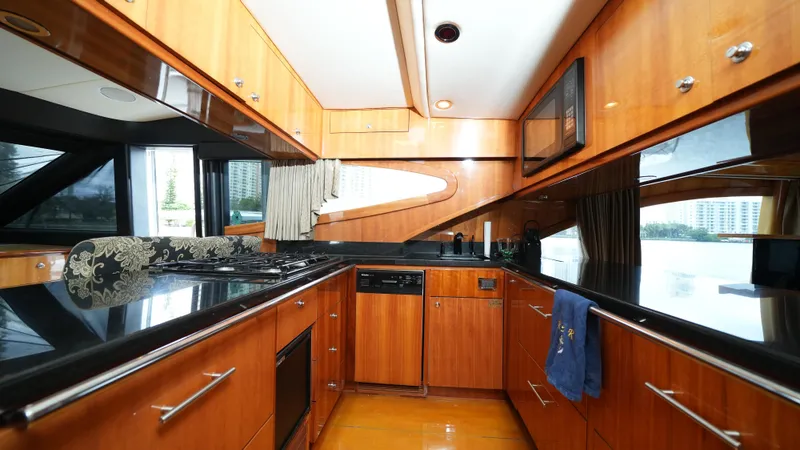 4 Princesses Yacht Photos Pics Luxurious kitchen interior of 2002 Queenship 70 Baretta yacht with wooden cabinetry and modern appliances.