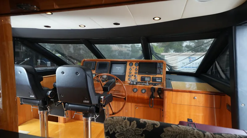 4 Princesses Yacht Photos Pics Interior helm of 2002 Queenship 70 Baretta yacht with dual captain chairs and navigation equipment.