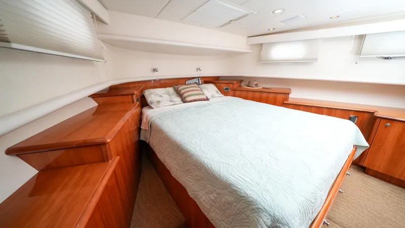 4 Princesses Yacht Photos Pics Luxurious bedroom interior of 2002 Queenship 70 Baretta yacht with wooden cabinetry.