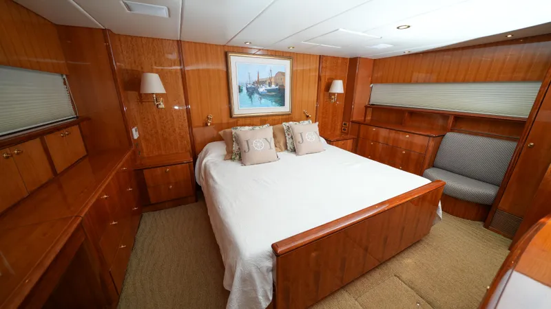 4 Princesses Yacht Photos Pics Luxurious master bedroom on a 2002 Queenship 70 Baretta yacht with wood paneling.