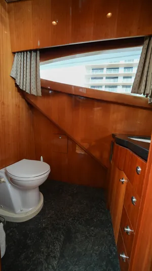 4 Princesses Yacht Photos Pics 2002 Queenship 70 Baretta yacht bathroom with wooden cabinetry and modern fixtures.