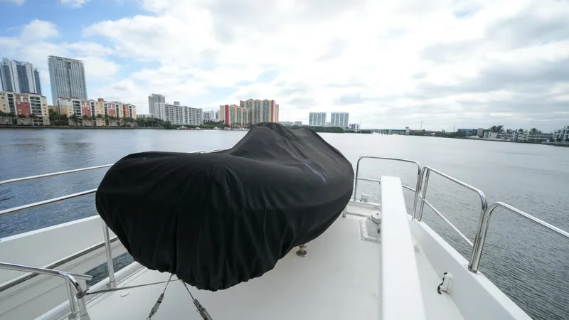 4 Princesses Yacht Photos Pics Covered equipment on the deck of a 2002 Queenship 70 Baretta yacht, with cityscape in the background.