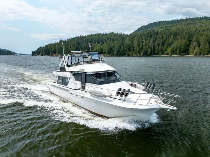 Kycournata Yacht Photos Pics Navigator 56 yacht cruising on a scenic lake, surrounded by lush green forests.