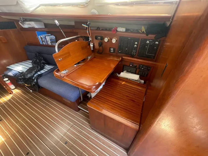 Argo Yacht Photos Pics Interior of 2004 Hunter 44 DS Deck Salon with wooden table and seating area.