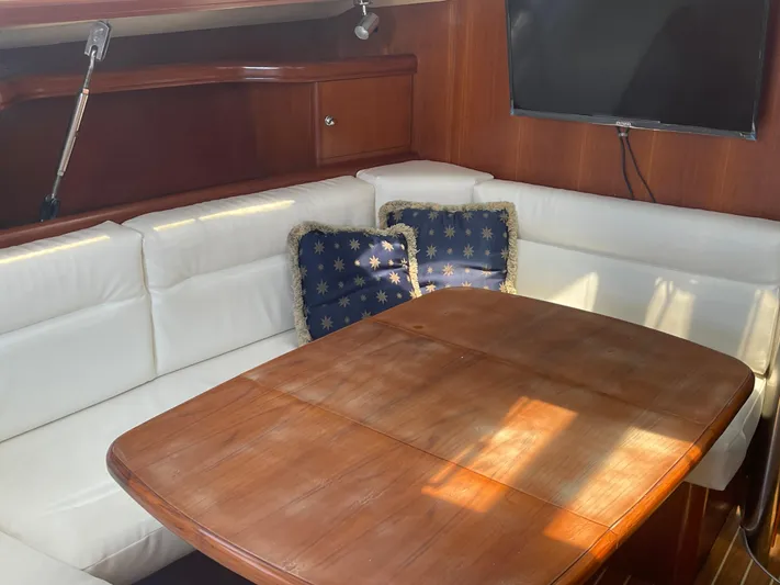 Argo Yacht Photos Pics Luxurious interior of 2004 Hunter 44 DS Deck Salon with wooden table and white seating.