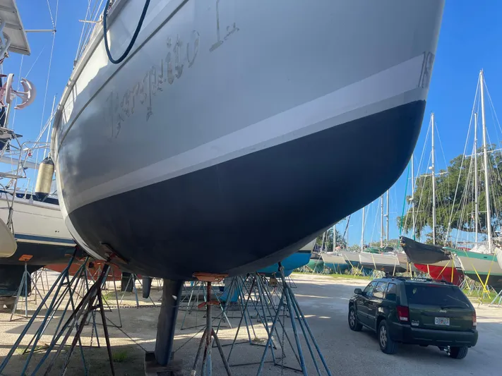Argo Yacht Photos Pics 2004 Hunter 44 DS Deck Salon sailboat on stands in a boatyard, with a car nearby.