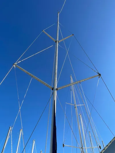 Argo Yacht Photos Pics Tall mast of a 2004 Hunter 44 DS Deck Salon sailboat against clear blue sky.