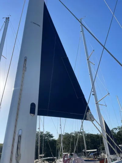 Argo Yacht Photos Pics Sailboat mast and sail of 2004 Hunter 44 DS Deck Salon under clear blue sky.