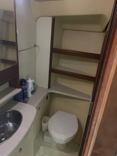 Argo Yacht Photos Pics 2004 Hunter 44 DS Deck Salon bathroom with sink, toilet, and storage shelves.