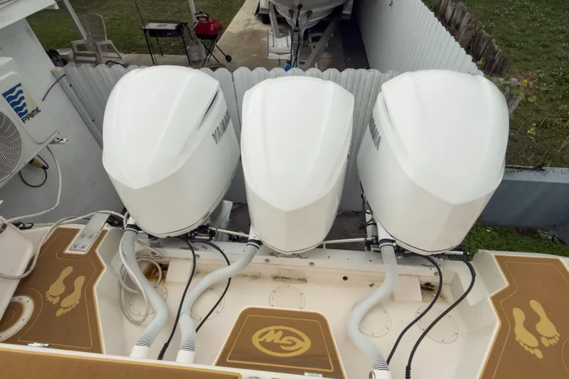  Yacht Photos Pics 2006 Grady-White Express 330 with triple Yamaha outboard engines, docked in a yard.