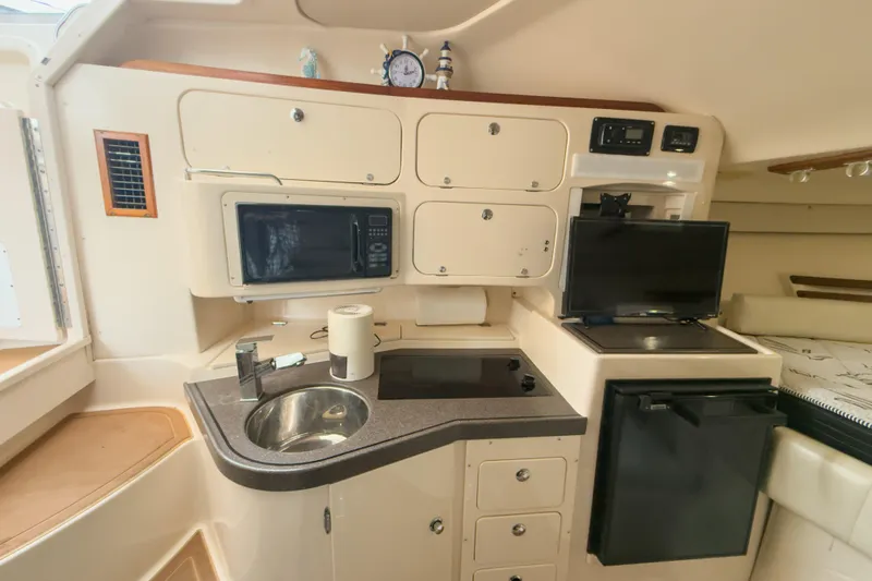  Yacht Photos Pics 2006 Grady-White Express 330 boat interior with kitchenette, microwave, sink, and TV.