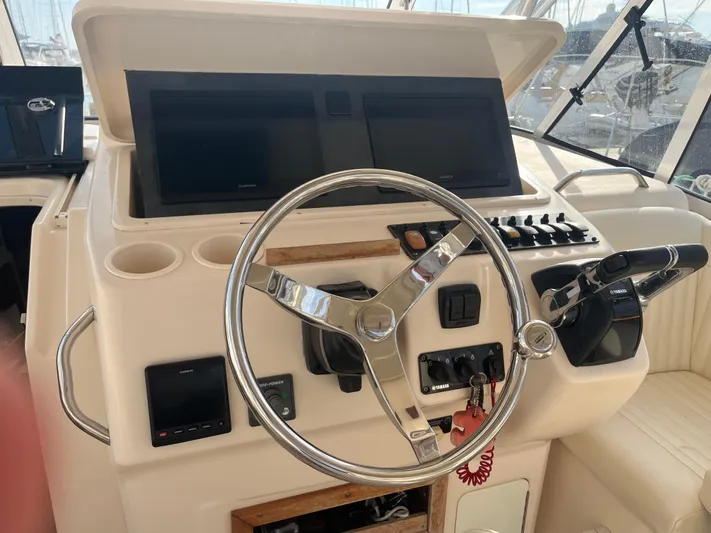  Yacht Photos Pics Helm of 2010 Grady-White Express 305 boat with steering wheel and control panel.