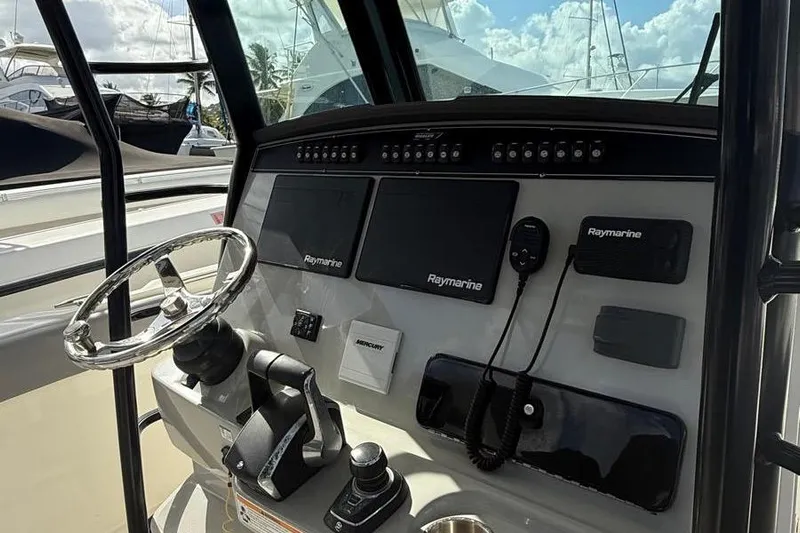  Yacht Photos Pics 2023 Boston Whaler 330 Outrage helm with Raymarine electronics and steering wheel.