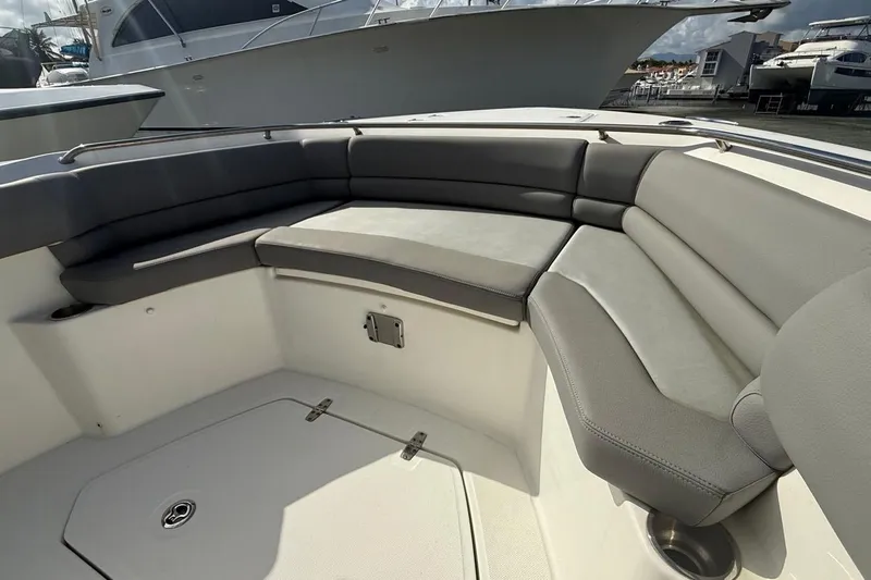  Yacht Photos Pics 2023 Boston Whaler 330 Outrage boat interior with cushioned seating area.