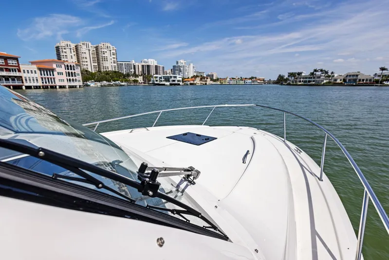 No Name Yacht Photos Pics 2025 Pursuit OS 355 Offshore boat cruising near urban waterfront skyline.