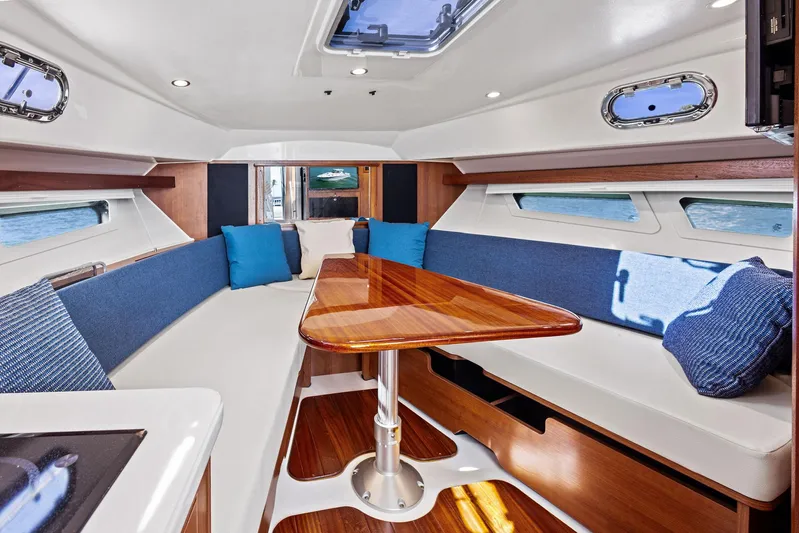 No Name Yacht Photos Pics Luxurious interior of 2025 Pursuit OS 355 Offshore yacht with elegant seating and wooden table.