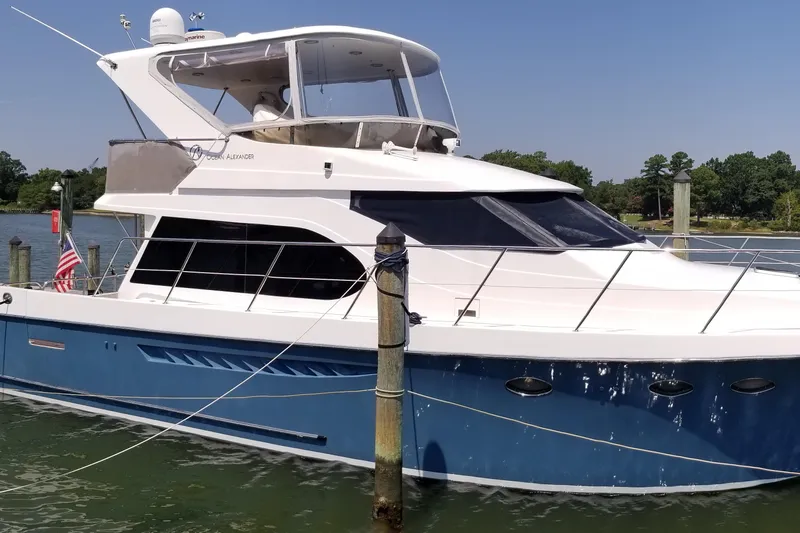 Apaiser Yacht Photos Pics 2005 Ocean Alexander 52 Sedan yacht docked in a marina, featuring a sleek blue and white design.