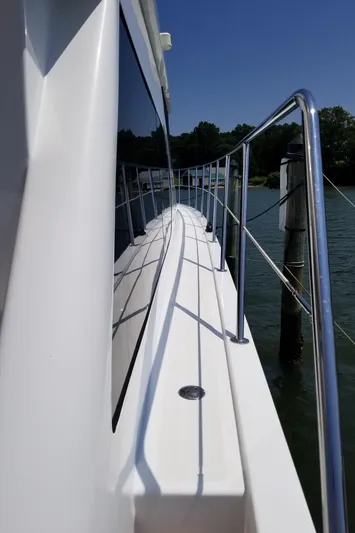 Apaiser Yacht Photos Pics 2005 Ocean Alexander 52 Sedan yacht deck with railing, reflecting water and sky.