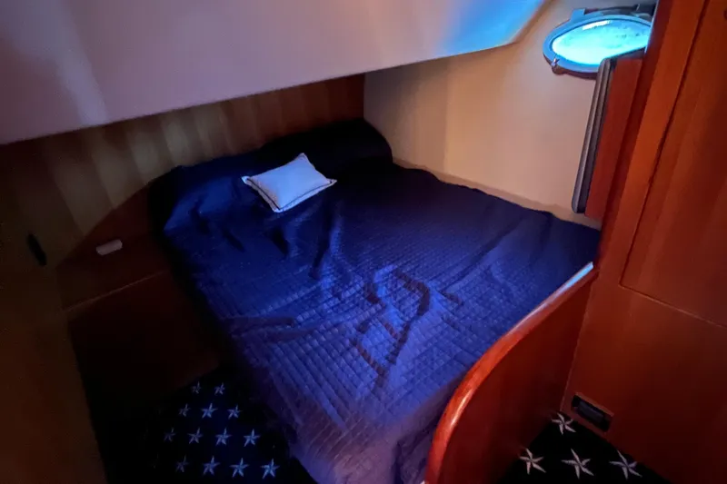 Apaiser Yacht Photos Pics Cozy bedroom in 2005 Ocean Alexander 52 Sedan yacht with blue bedding and porthole.