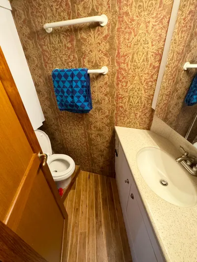  Yacht Photos Pics Bathroom interior of 2005 Ocean Yachts 46 Super Sport with patterned wallpaper and wooden flooring.