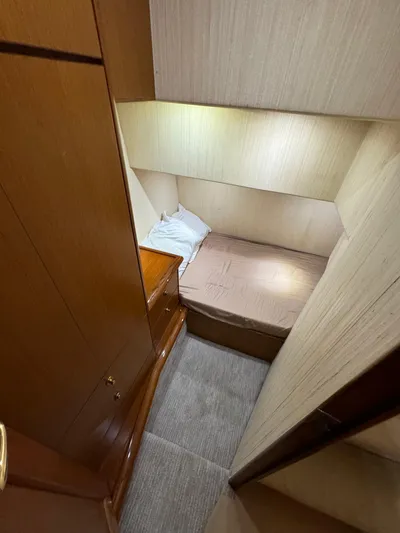  Yacht Photos Pics Small cabin interior of 2005 Ocean Yachts 46 Super Sport with bed and wooden cabinetry.