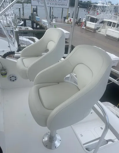  Yacht Photos Pics Two white captain's chairs on a 2005 Ocean Yachts 46 Super Sport at a marina.