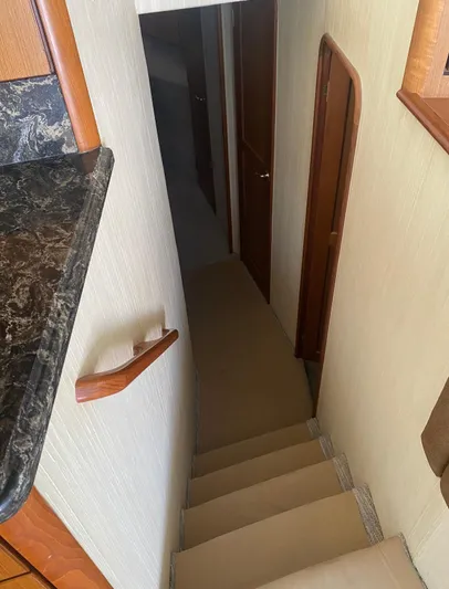  Yacht Photos Pics Staircase inside 2005 Ocean Yachts 46 Super Sport, featuring wooden handrails and carpeted steps.