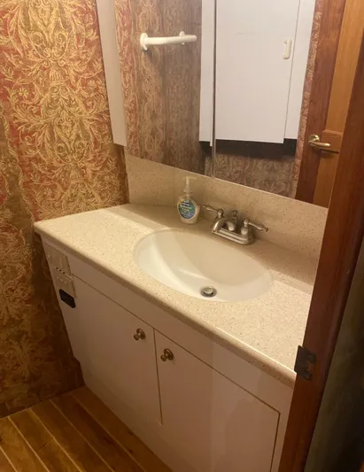  Yacht Photos Pics Bathroom vanity in 2005 Ocean Yachts 46 Super Sport, featuring elegant wallpaper and wooden flooring.