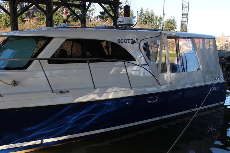  Yacht Photos Pics 2016 Aspen B100 boat docked under a wooden structure.