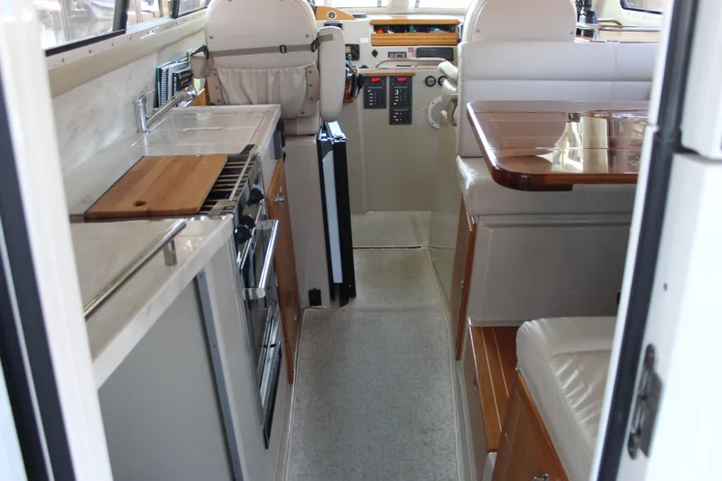  Yacht Photos Pics Interior of a 2016 Aspen B100 boat featuring a compact kitchen and seating area.