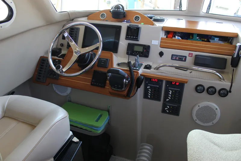  Yacht Photos Pics Interior of a 2016 Aspen B100 boat cockpit with steering wheel and control panels.