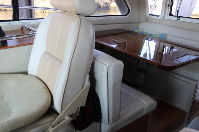  Yacht Photos Pics 2016 Aspen B100 boat interior with cushioned seating and polished wooden table.