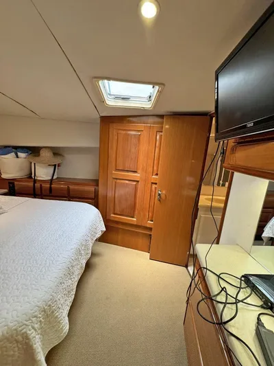  Yacht Photos Pics 1998 Viking 58 Convertible yacht bedroom with TV, wooden cabinets, and skylight.