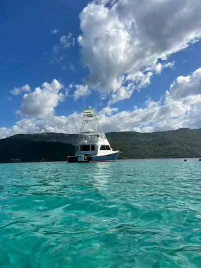  Yacht Photos Pics 1998 Viking 58 Convertible yacht on clear turquoise water with scenic mountain backdrop.