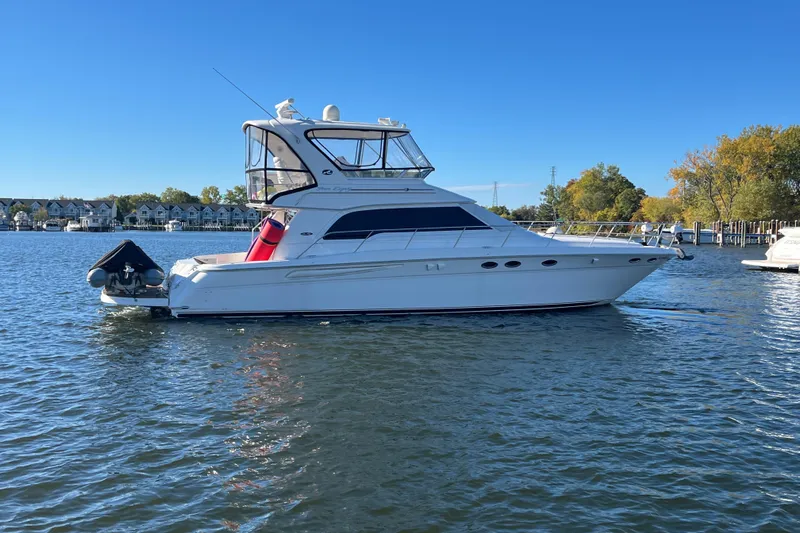  Yacht Photos Pics 2003 Sea Ray 480 Sedan Bridge yacht on calm water, clear sky background.