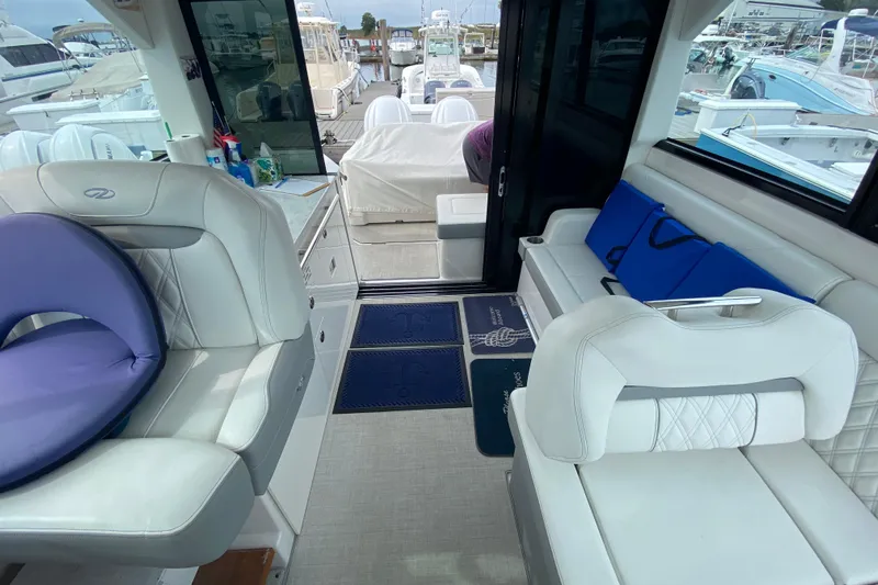 Camelot Yacht Photos Pics Interior of 2022 Regal 36 XO yacht with white seating and blue accents.