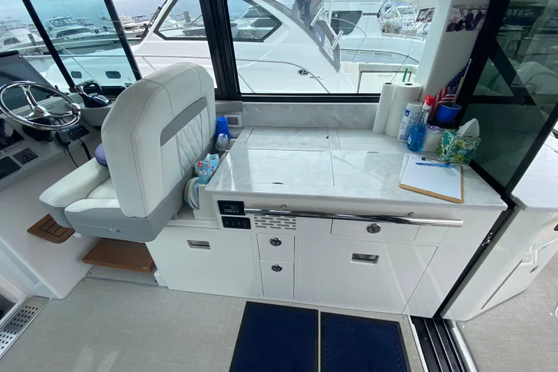 Camelot Yacht Photos Pics 2022 Regal 36 XO yacht interior with helm, countertop, and storage cabinets.