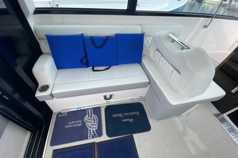 Camelot Yacht Photos Pics 2022 Regal 36 XO boat interior with white seating and blue cushions.