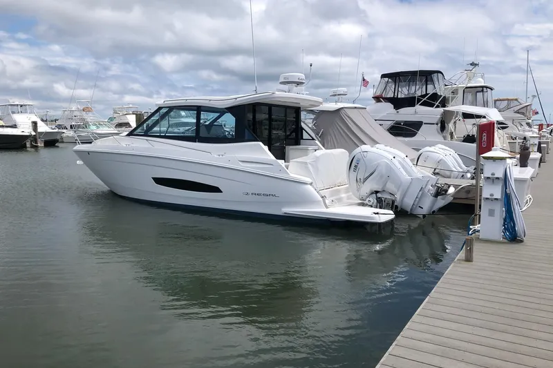 Camelot Yacht Photos Pics 2022 Regal 36 XO boat docked at marina with other vessels.