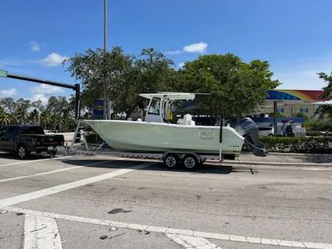  Yacht Photos Pics 2022 Sea Hunt 27 Gamefish boat on a trailer at an intersection.
