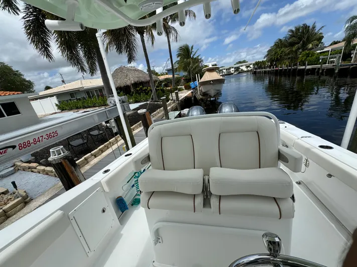  Yacht Photos Pics 2022 Sea Hunt 27 Gamefish boat docked by a canal with palm trees.