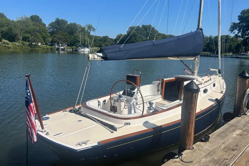  Yacht Photos Pics 2008 Alerion Express 33 sailboat docked on a calm river, surrounded by trees.