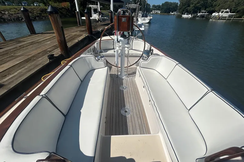  Yacht Photos Pics 2008 Alerion Express 33 sailboat with white seating and wooden deck, docked by a pier.