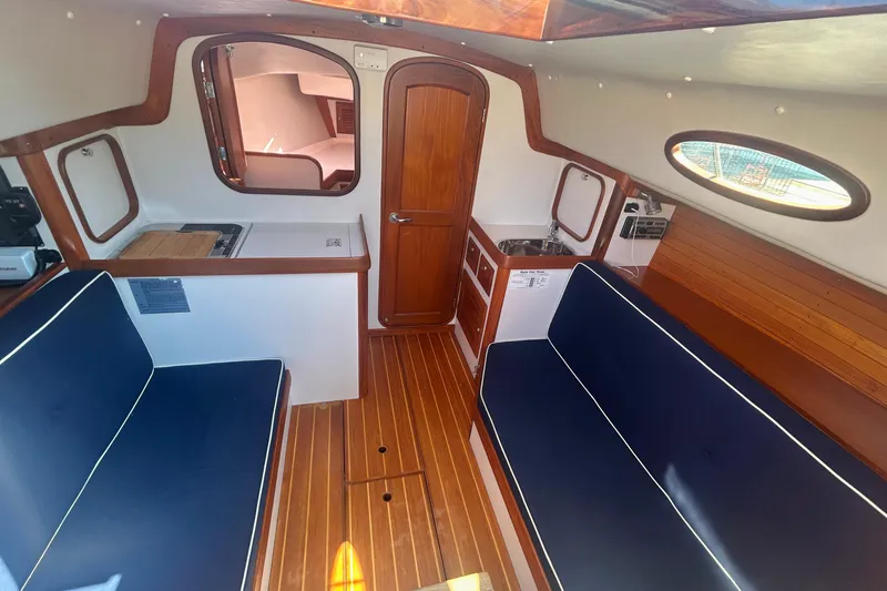  Yacht Photos Pics Interior of 2008 Alerion Express 33 sailboat with wooden finishes and blue seating.