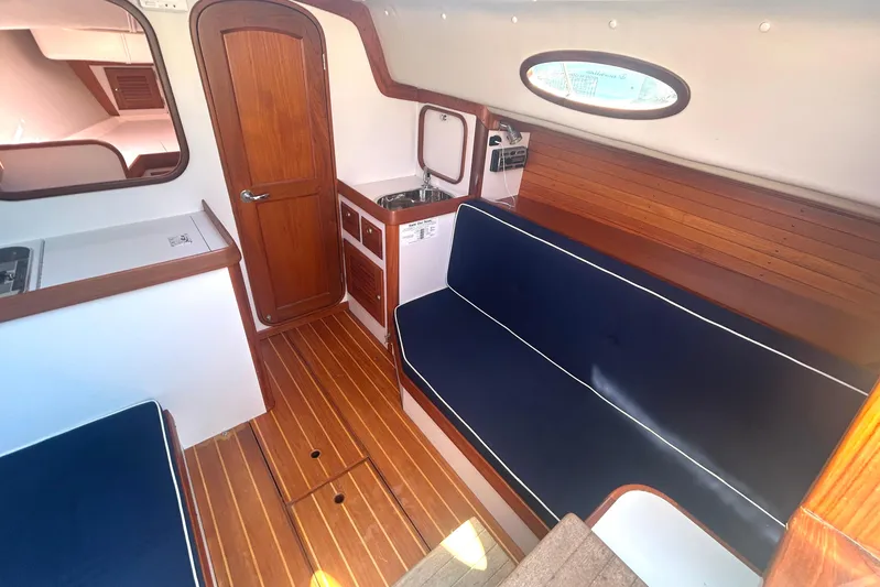  Yacht Photos Pics Interior of 2008 Alerion Express 33 sailboat with wooden finishes and blue seating.