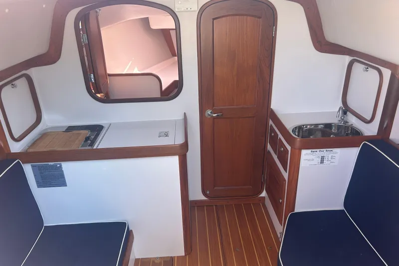  Yacht Photos Pics Interior of 2008 Alerion Express 33 sailboat with wood finishes and compact kitchenette.