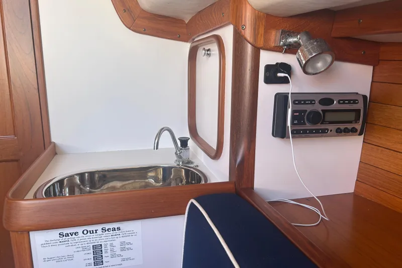  Yacht Photos Pics Interior of 2008 Alerion Express 33 sailboat with sink, radio, and wooden finish.