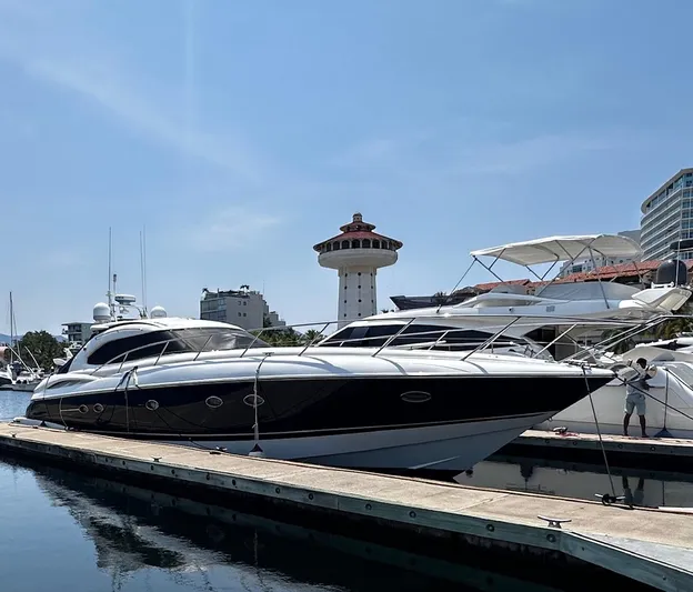 Hot Stuff Yacht Photos Pics Sunseeker Predator 56 yacht docked at marina, clear sky, 2000 model.