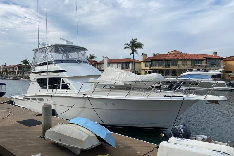  Yacht Photos Pics 1995 Hatteras 50 Convertible Sportfish yacht docked in a marina with waterfront homes.