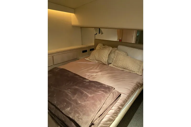  Yacht Photos Pics Cozy bedroom interior of 1995 Hatteras 50 Convertible Sportfish yacht with plush bedding.
